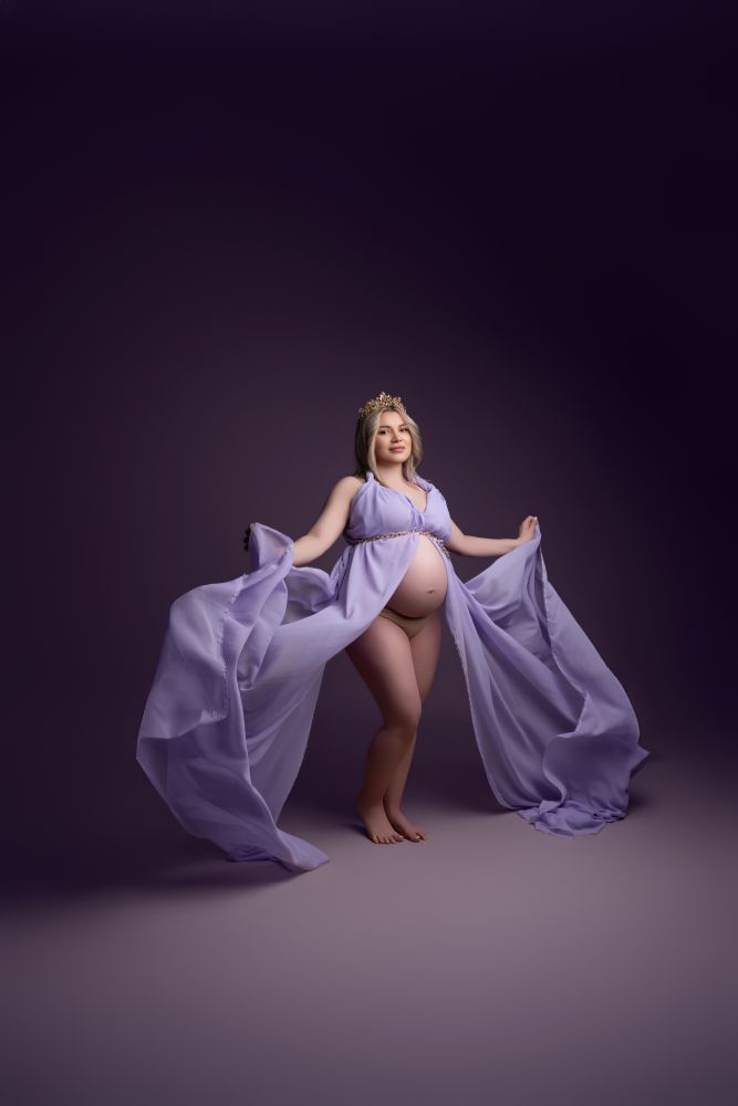 Photo d'une femme enceinte sur fond violet, prise par la photographe Claudia Pereira, cliente chez fond-photo.fr