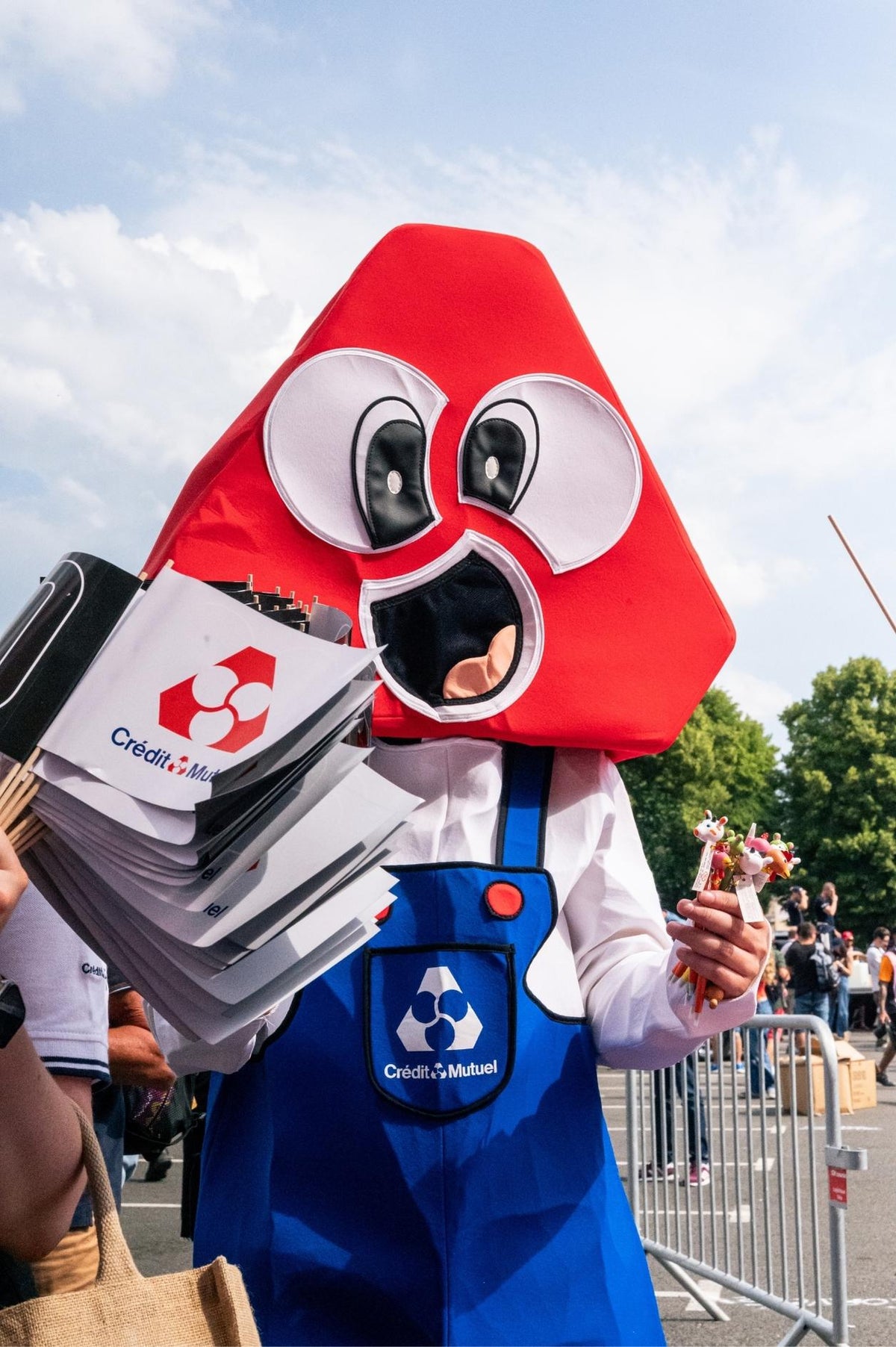 Mascotte du Crédit Mutuel en tablier bleu lors d'un événement en plein air, photo corporate de Bastien Plu