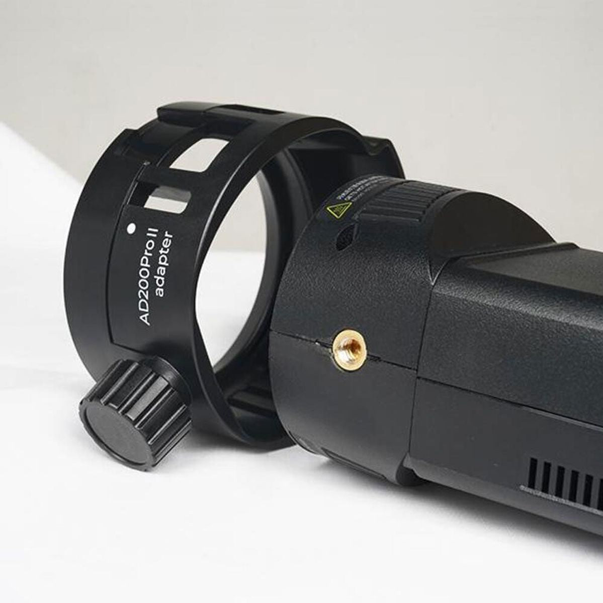 Adaptateur flash SMDV Speedbox-Flip AD200Pro II posé devant la tête d'un Godox AD200Pro II avant montage