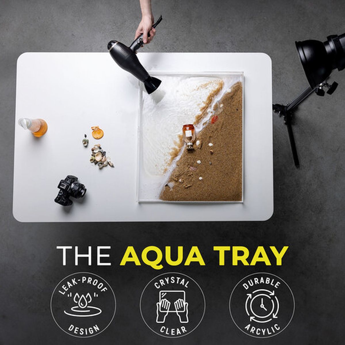 Bac Aqua Tray rempli de sable et d'eau sur une table de studio, scène de plage en préparation