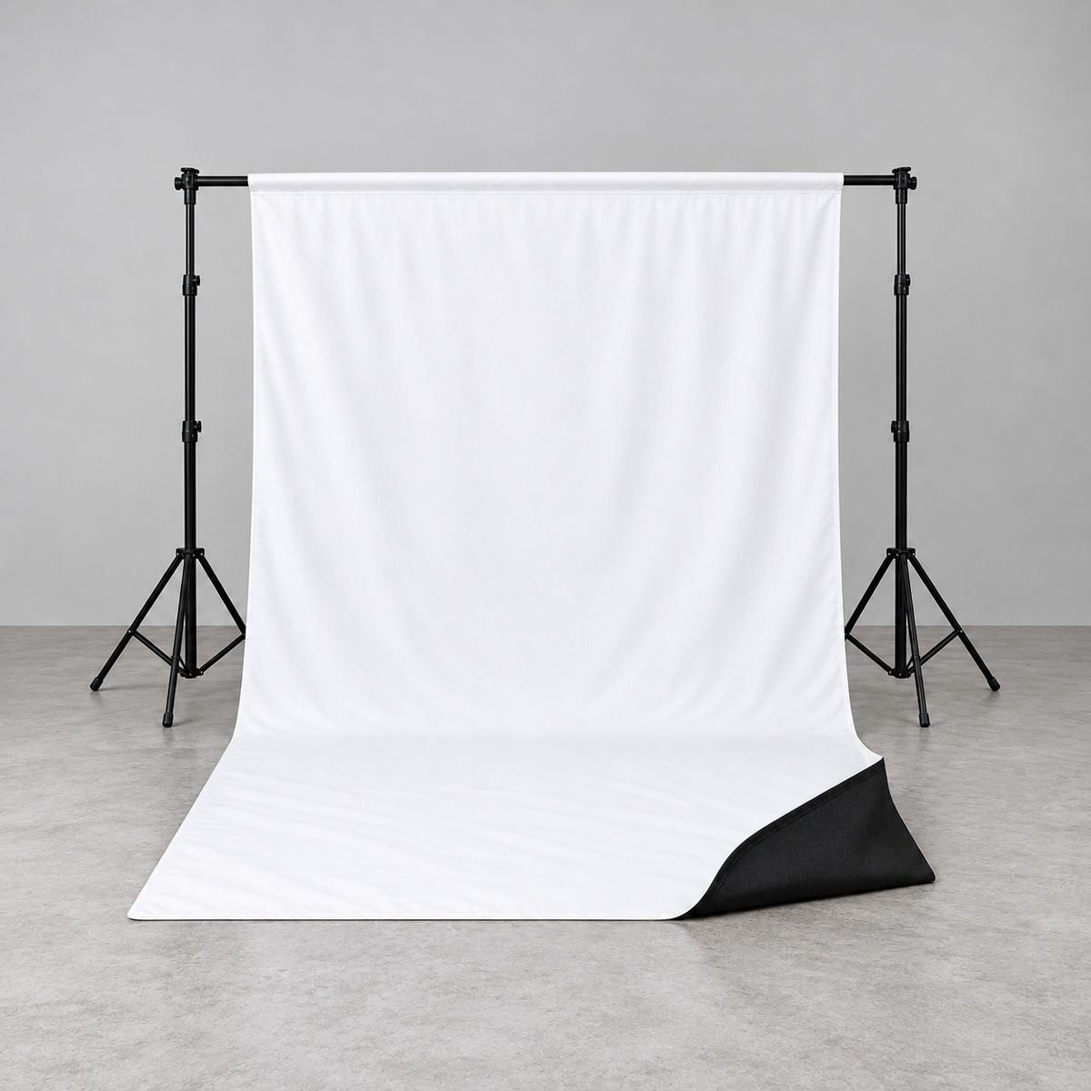 Toile de fond photo réversible StudioKing 2,7 x 5 m montée sur un support de fond, face blanche déroulée au sol et coin retroussé sur la face noire (support non fourni)
