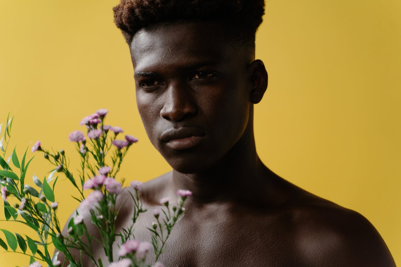 Homme tenant des fleurs sur un arrière-plan photographique jaune