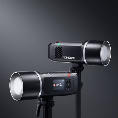 Deux flashs portables Godox AD600BM II montés sur des pieds, réflecteurs en place