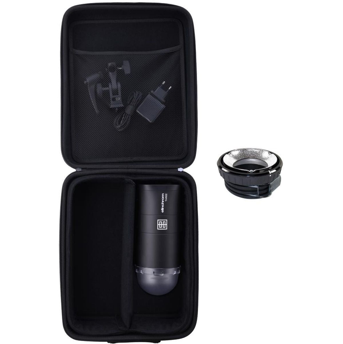Étui ouvert du kit flash portable Elinchrom THREE avec le flash, le chargeur et l'OCF Adapter posé à côté