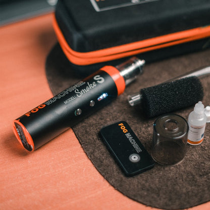 Machine à fumée Lensgo Smoke S posée avec sa télécommande et sa buse