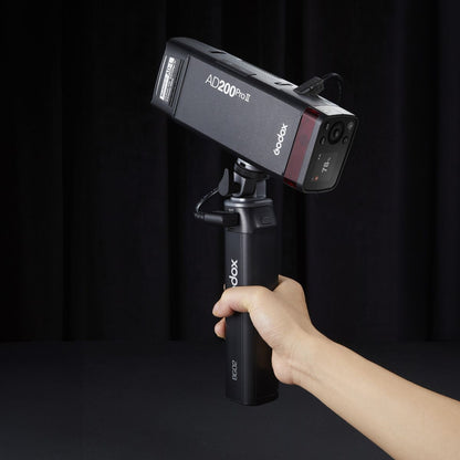 Poignée batterie Godox BG02 tenue en main avec un flash AD200Pro II relié par câble